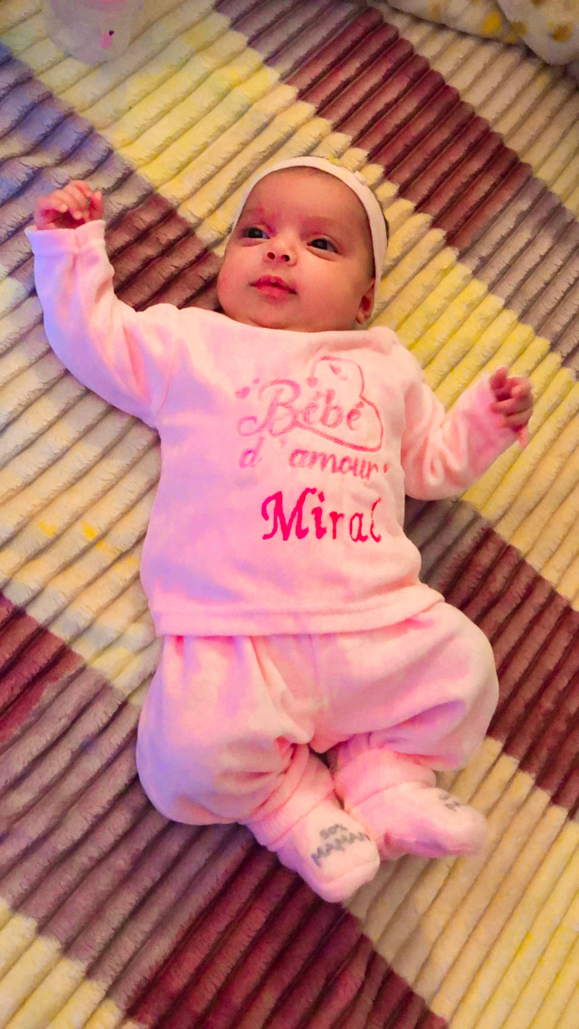 Miral participe au concours pour gagner de l'argent avec cette photo : arm, baby, baby_toddler_clothing, cheek, child, comfort, face, flooring, foot, fun, happy, hardwood, headwear, magenta, outerwear, person, pink, skin, sleeve, t_shirt