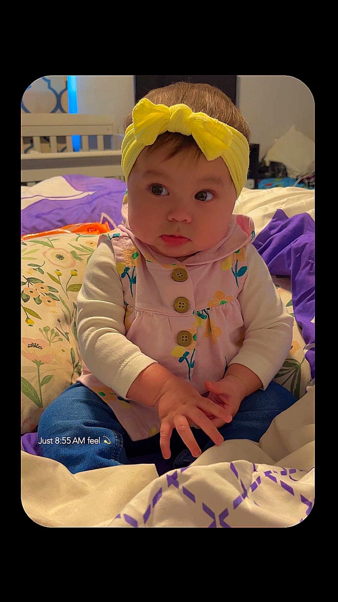 Isabella is registered to the contest to win money with this photo: baby, infant, face, headband, yellow_headband, dress, buttons, hands, bed, pillow, blanket, bedding, room, portrait, cute, sitting, eyes, cheeks, indoors, child