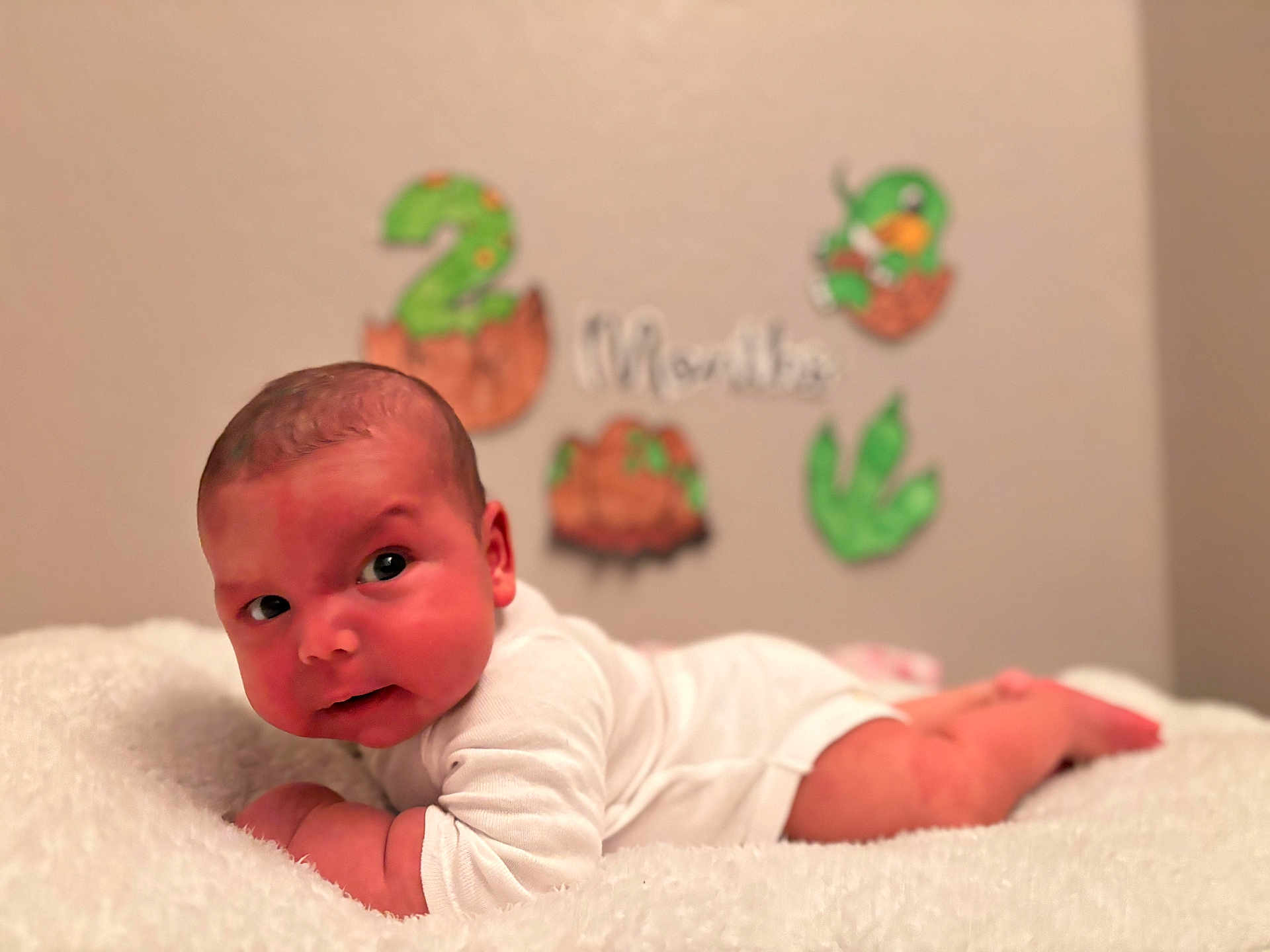 Thiago Solano is registered to the contest to win money with this photo: baby, infant, white_clothing, blanket, lying_down, face, head, skin, newborn, child, cute, indoors, celebration, decorations, number_two, months, soft_texture, resting, portrait, expression