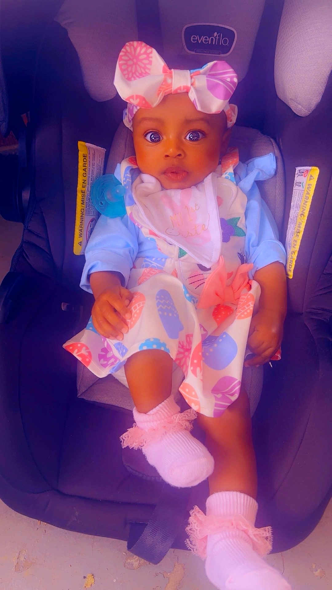 Autumn is registered to the contest to win money with this photo: baby, child, car_seat, headband, bow, dress, pink_socks, pacifier, infant, cute, wide_eyes, seated, clothing, indoor, person, adorable, colorful, fabric, footwear, young