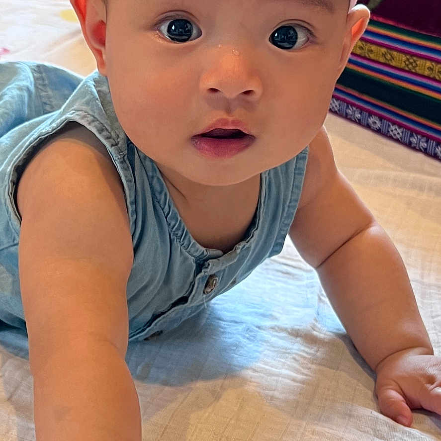 Tenyang joined the competition — help win amazing prizes! baby, child, infant, crawling, portrait, indoors, bed, headband, pink, bow, blue_clothing, smiling, curious, face, eyes, hands, blanket, bedroom, colorful, photography