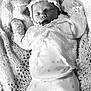 baby, newborn, sleeping, knitted_clothing, bonnet, blanket, soft_texture, monochrome, portrait, infant, peaceful, cute, cozy, laying_down, small_hands, white_clothing, delicate, closeup, baby_fashion, resting