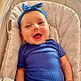 baby, smiling, blue_headband, blue_shirt, baby_seat, cushion, happy, infant, person, portrait, cute, child, indoors, comfortable, face, headwear, clothing, skin, hand, relaxed