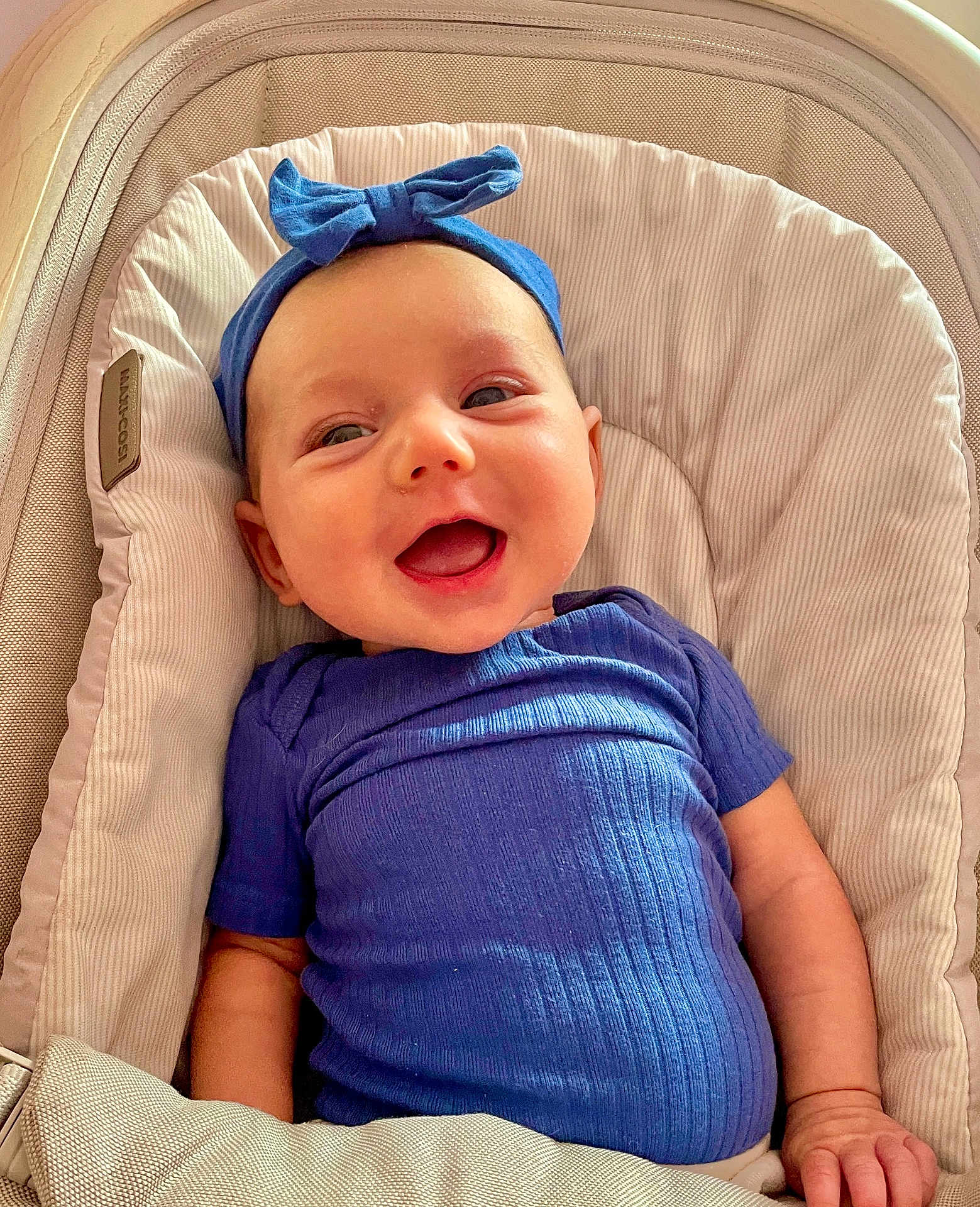 Liliana joined the competition — help win amazing prizes! baby, smiling, blue_headband, blue_shirt, baby_seat, cushion, happy, infant, person, portrait, cute, child, indoors, comfortable, face, headwear, clothing, skin, hand, relaxed