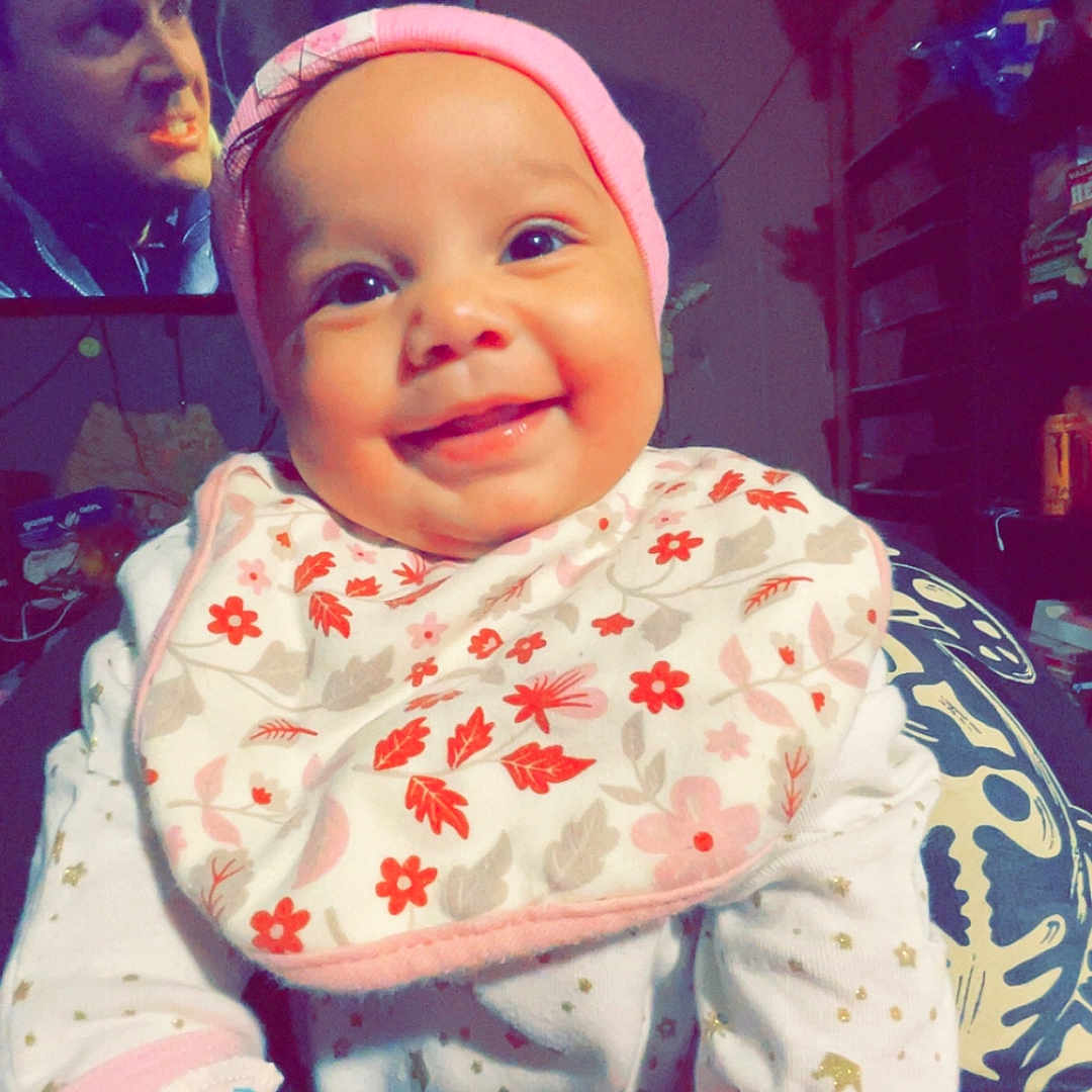 Davina joined the competition — help win amazing prizes! baby, background, bib, child, clothing, cozy, cute, expression, face, furniture, happy, hat, indoor, mittens, patterned, person, portrait, room, smiling, television