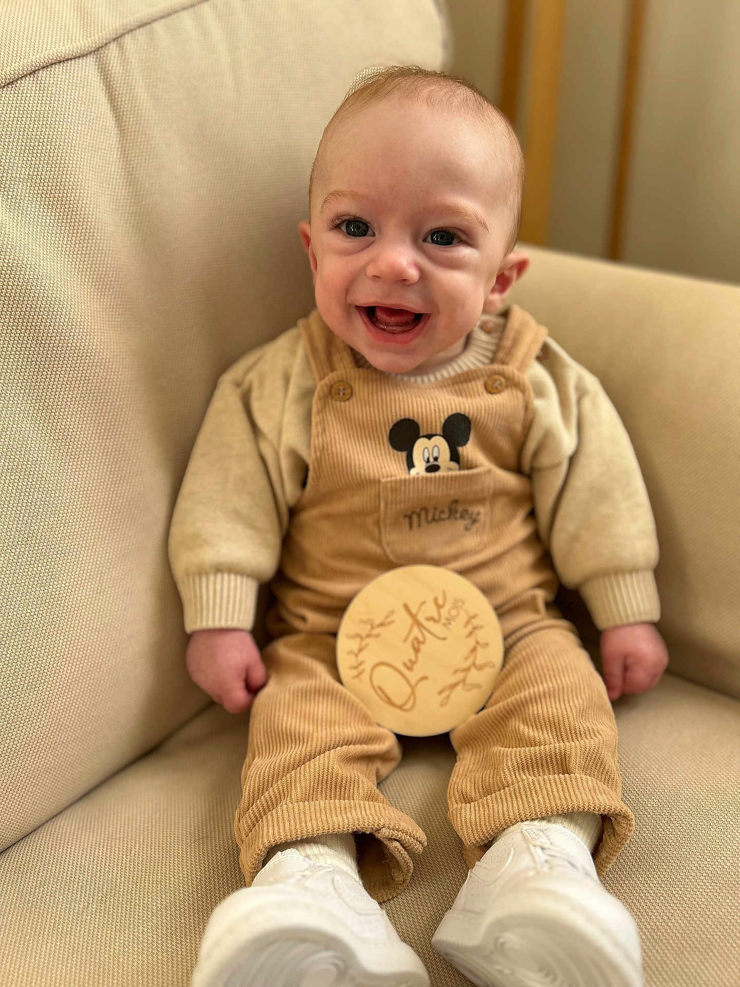 Nino a rejoint le concours — aidez-le/la à gagner de superbes lots ! baby, child, clothing, corduroy, couch, cozy, cute, face, feet, hands, happy, indoors, infant, mickey_mouse, overalls, portrait, sitting, smiling, white_shoes, young