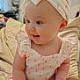 Isla joined the competition — help win amazing prizes! baby, child, infant, headband, smiling, clothing, sitting, bed, pillow, indoors, cute, happy, portrait, person, pink_pants, soft_lighting, home, young, floral_pattern, cheeks