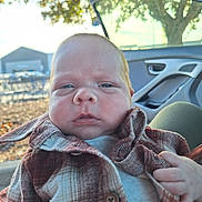 Jaxson joined the competition — help win amazing prizes! baby, infant, face, plaid_jacket, clothing, hand, car_interior, car_door, window, tree, sunlight, outdoor, parking_lot, daylight, person, portrait, young_child, button, fabric, seat