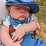 Jaxson is registered to the contest to win money with this photo: baby, sleeping, blue_clothing, bow_tie, cap, suspenders, outdoor, grass, trees, hands, face, cute, child, person, close_up, infant, peaceful, nature, portrait, resting