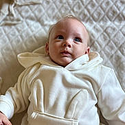 April participe au concours pour gagner de l'argent avec cette photo : baby, child, infant, hoodie, white_clothing, bunny_ears, blanket, soft_texture, blue_eyes, cute, portrait, lying_down, indoors, cozy, young_child, face, expression, casual_clothing, warm, comfortable