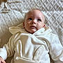 baby, child, infant, hoodie, white_clothing, bunny_ears, blanket, soft_texture, blue_eyes, cute, portrait, lying_down, indoors, cozy, young_child, face, expression, casual_clothing, warm, comfortable