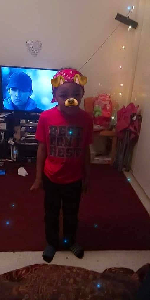 Josh is registered to the contest to win money with this photo: baseball_cap, cap, display_device, electric_blue, entertainment, event, eyewear, flooring, fun, hat, headwear, led_backlit_lcd_display, leisure, magenta, party, performing_arts, person, pink, room, t_shirt