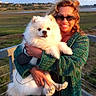 Harley joined the competition — help win amazing prizes! woman, dog, white_dog, pet, outdoor, balcony, green_sweater, sunglasses, smiling, happy, fluffy, grass, landscape, cloudy_sky, holding, portrait, nature, daylight, fence, leash