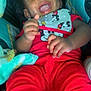 Major is registered to the contest to win money with this photo: baby, child, infant, smiling, laughing, red_clothing, mickey_mouse, bib, blanket, car_seat, bottle, happy, cute, hands, face, portrait, indoor, comfort, joy, young