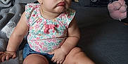 Ocean is registered to the contest to win money with this photo: baby, bed, blanket, child, clothing, cute, denim, expression, face, floral, footwear, furniture, hair, indoor, person, sandals, shorts, sitting, skin, toddler