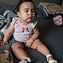 Ocean is registered to the contest to win money with this photo: toddler, child, baby, sitting, bed, blanket, clothing, floral, denim, shorts, sandals, footwear, indoor, furniture, expression, face, hair, skin, person, cute