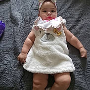 Ocean joined the competition — help win amazing prizes! baby, infant, child, blanket, clothing, headband, bib, cute, lying_down, indoors, plush, soft_texture, pink, white, expression, face, legs, feet, footwear, bedspread