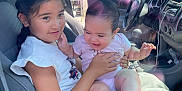 Ocean joined the competition — help win amazing prizes! child, baby, girl, car_interior, seat, seatbelt, smiling, holding, sunlight, reflection, window, clothing, shorts, tshirt, happy, family, indoors, vehicle, dashboard, steering_wheel