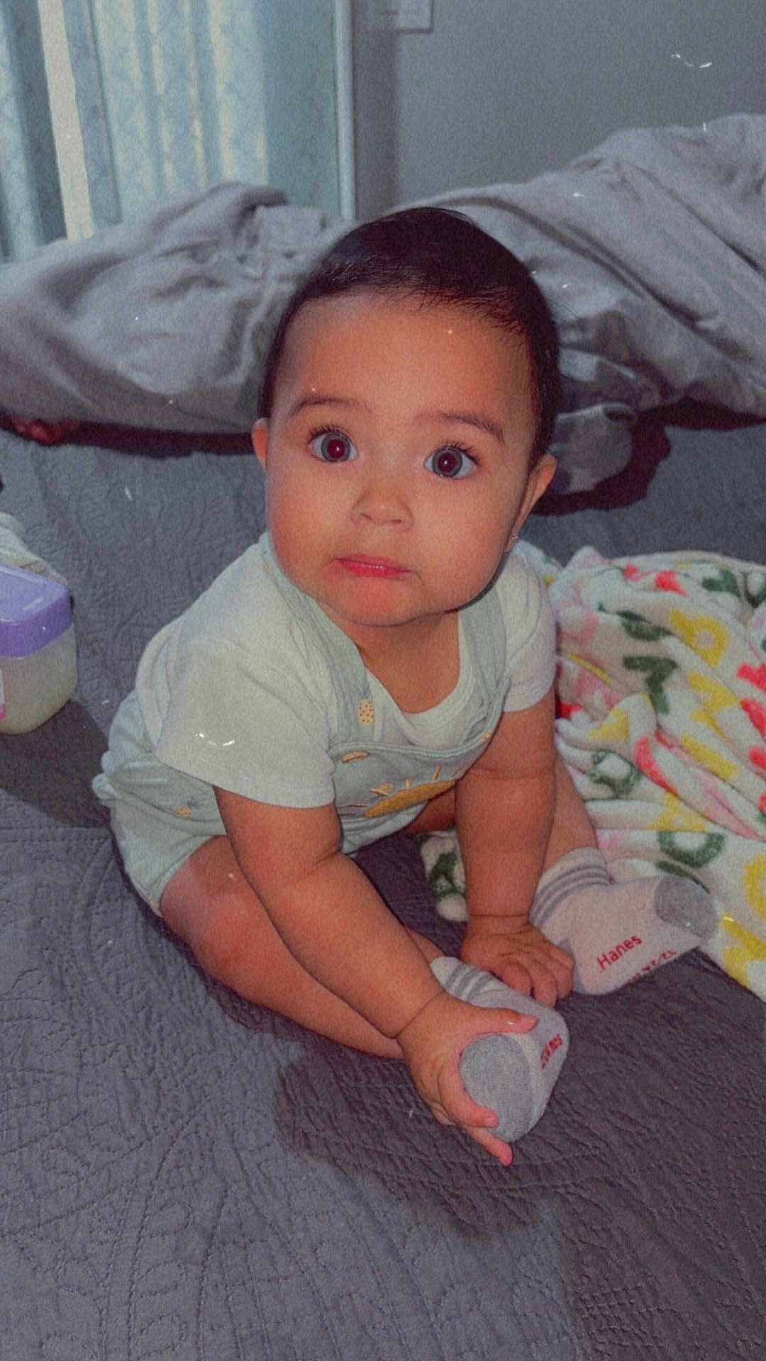 Ocean joined the competition — help win amazing prizes! baby, child, sitting, bed, blanket, sock, clothing, foot, hand, face, expression, indoors, curious, cute, infant, soft_lighting, home, cozy, person, portrait