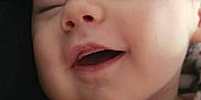 Clover is registered to the contest to win money with this photo: baby, smiling, face, close_up, child, sleepy, happy, infant, portrait, soft, indoors, cozy, clothing, red, white, skin, head, cute, expression, young