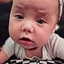 Clover is registered to the contest to win money with this photo: baby, child, headband, bow, closeup, face, expression, curious, infant, skin, eyes, mouth, cheeks, clothing, pattern, black_and_white, checkered, portrait, indoors, person