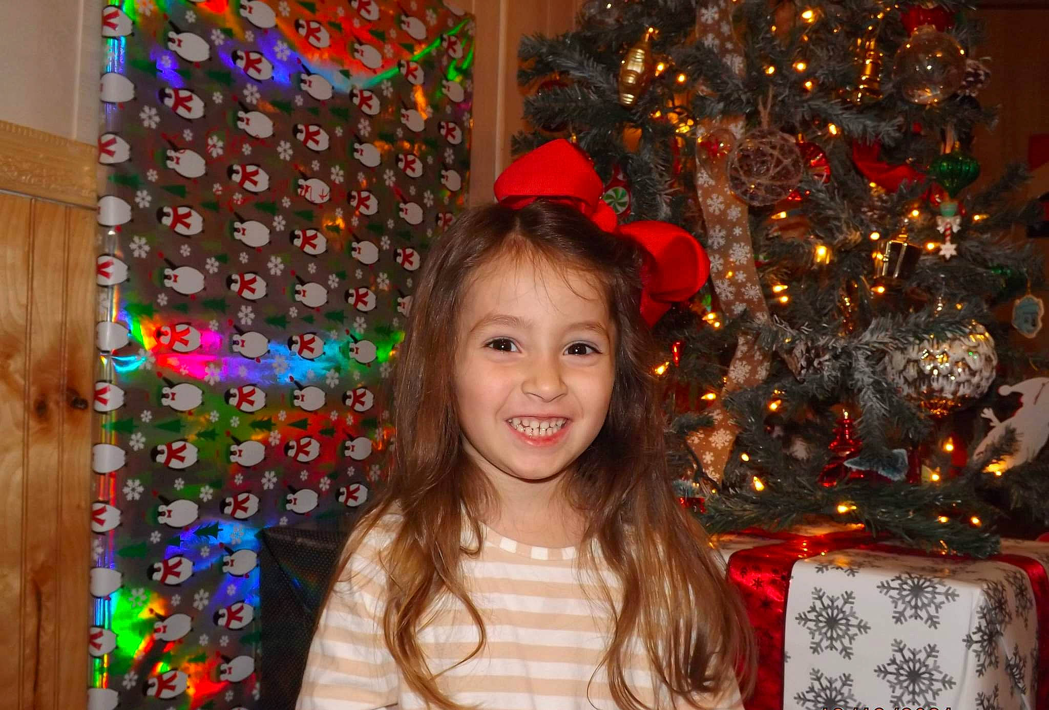Elena joined the competition — help win amazing prizes! christmas_decoration, christmas_eve, christmas_ornament, christmas_tree, costume_hat, event, fun, happy, hat, holiday, holiday_ornament, joy, ornament, party_supply, people, person, smile, snapshot, standing, toddler