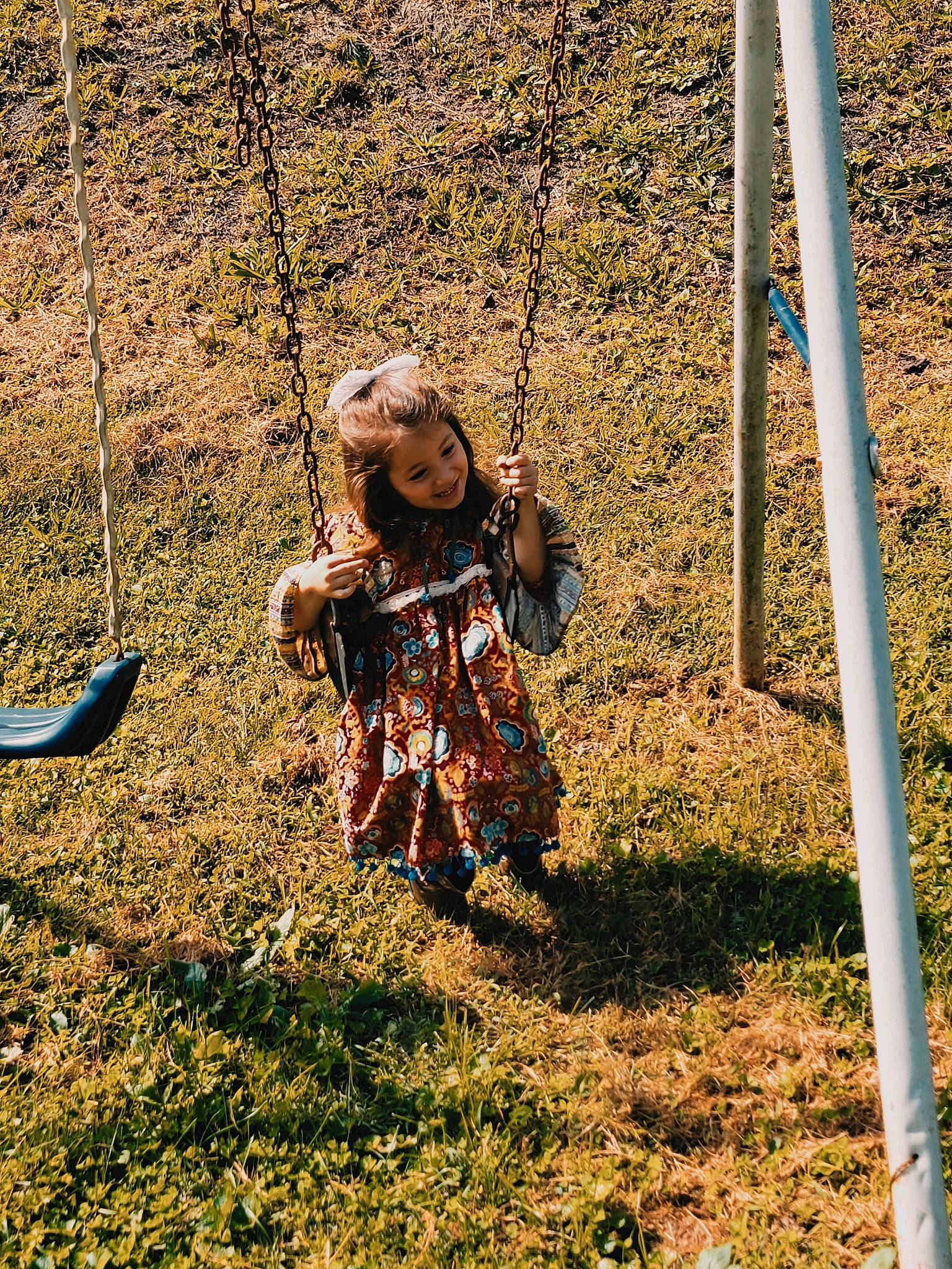 Elena is registered to the contest to win money with this photo: baby, child, city, fun, grass, joy, leisure, mesh, outdoor_play_equipment, pattern, people_in_nature, person, plant, play, playground, recreation, shade, soil, swing, toddler