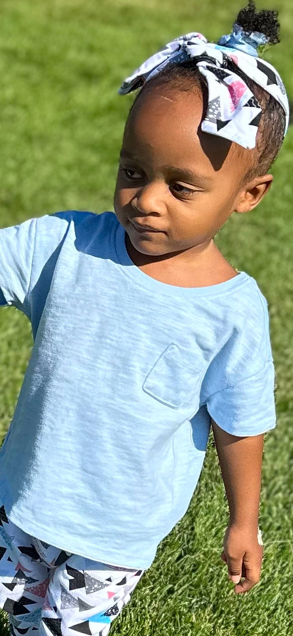 Mariah is registered to the contest to win money with this photo: azure, child, cool, electric_blue, eye, eyelash, face, flash_photography, fun, gesture, grass, happy, head, leisure, neck, people_in_nature, person, sleeve, smile, t_shirt