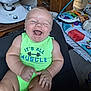 Riven is registered to the contest to win money with this photo: baby, child, smiling, laughing, onesie, green_clothing, indoor, toy, colorful, face, person, infant, happy, furniture, playmat, candid, expression, skin, hand, seated