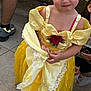 Miléna a rejoint le concours — aidez-le/la à gagner de superbes lots ! child, girl, yellow_dress, princess_costume, smile, outdoor, party, snacks, table, flower, red_rose, lace, pavement, people, footwear, hair_accessories, cute, celebration, face, portrait