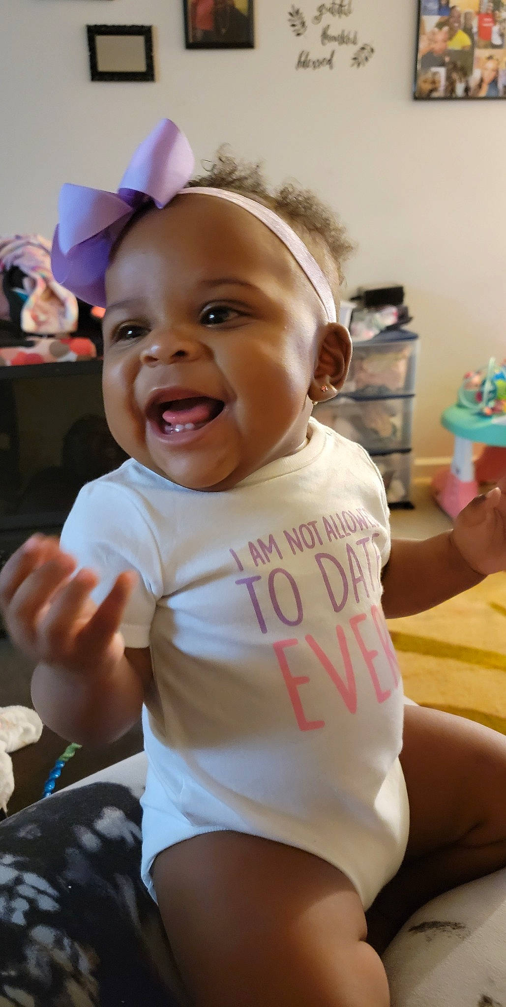 Khloe Kay is registered to the contest to win money with this photo: arm, baby, baby_toddler_clothing, face, facial_expression, finger, fun, gesture, hairstyle, hand, happy, mouth, person, pink, product, skin, smile, standing, thumb, toddler