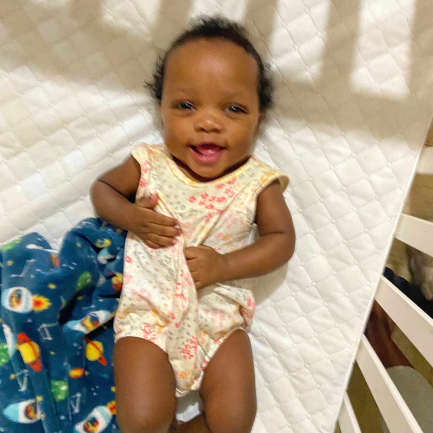 Avalynn is registered to the contest to win money with this photo: baby, bed, blanket, clothing, crib, cushion, dress, face, furniture, happy, head, homedecor, infantbed, person, photography, portrait, quilt, sitting, smile, standing