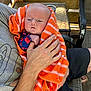 Knox joined the competition — help win amazing prizes! baby, towel, orange, striped, hand, adult, porch, wood, chair, table, cup, clothing, person, sitting, casual, outdoor, relaxation, comfort, infant, holding