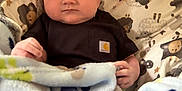 Knox is registered to the contest to win money with this photo: baby, blanket, infant, face, clothing, person, cute, indoors, animal_print, soft, cozy, toddler, warm, comfort, portrait, child, expressionless, head, sitting, young