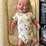 baby, infant, smiling, onesie, koala_print, lying_down, cushion, changing_pad, blanket, indoors, cute, child, happy, skin, person, head, face, arm, leg, comfort