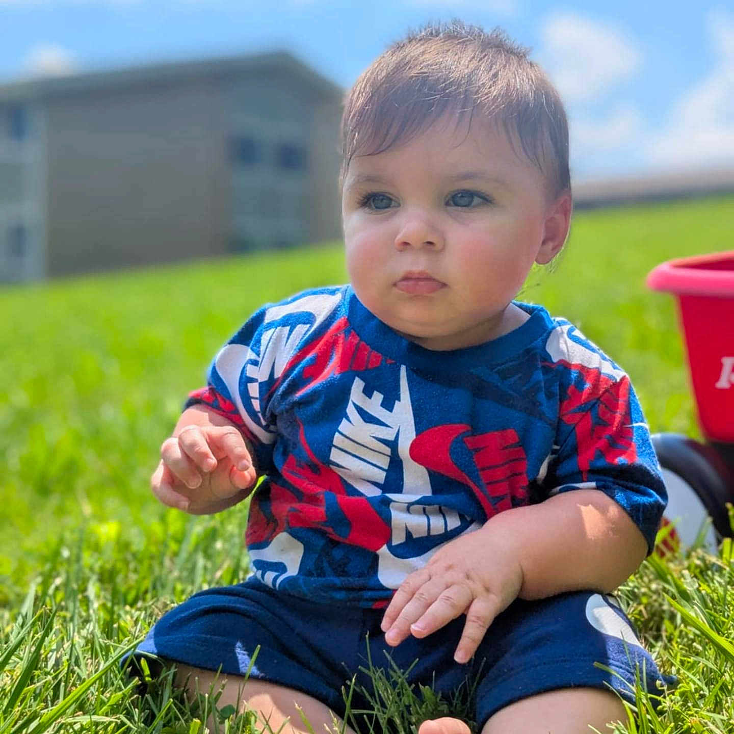 Rylann joined the competition — help win amazing prizes! barefoot, blue_sky, casual_clothing, child, clouds, cute, daytime, expression, grass, greenery, nature, outdoor, portrait, shirt, shorts, sitting, summer, sunlight, toddler, toy_wagon
