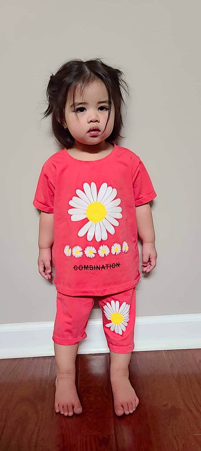 Katie is registered to the contest to win money with this photo: arm, baby_toddler_clothing, black, cheek, clothing, dress, eye, face, hair, hand, happy, human_body, neck, organ, person, pink, skin, sleeve, standing, t_shirt