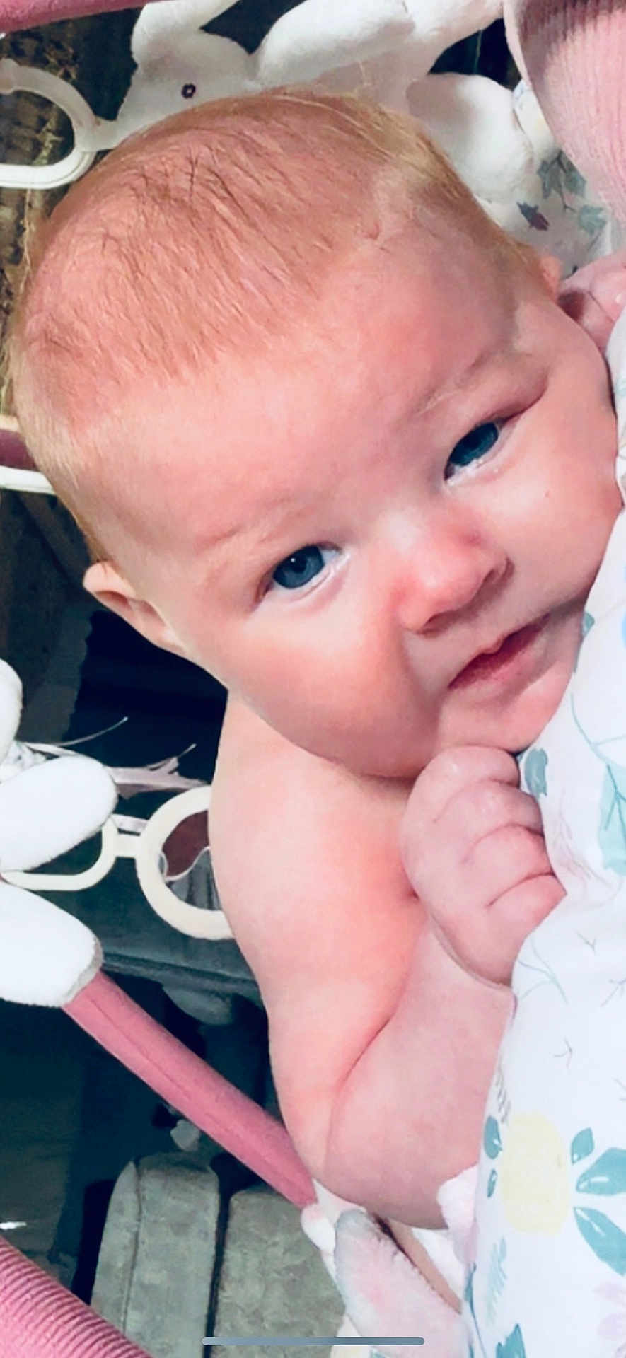 Amalia is registered to the contest to win money with this photo: baby, infant, blue_eyes, close_up, blanket, soft_toy, hand, face, skin, expression, cute, child, indoor, portrait, newborn, pink, floral_pattern, baby_gear, young_child, tender_moment