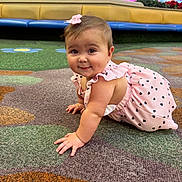 Allison joined the competition — help win amazing prizes! baby, infant, child, crawling, carpet, pink_dress, bow, smile, face, eyes, hands, cute, indoor, mall, seating, bench, pattern, play_area, floor, ground
