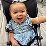 Allison joined the competition — help win amazing prizes! baby, infant, smiling, stroller, blue_dress, hair_bows, buckled, cheeks, tongue, wide_eyes, skin, arm, hand, indoor, tile_floor, metal_frame, close_up, portrait, happy, cute