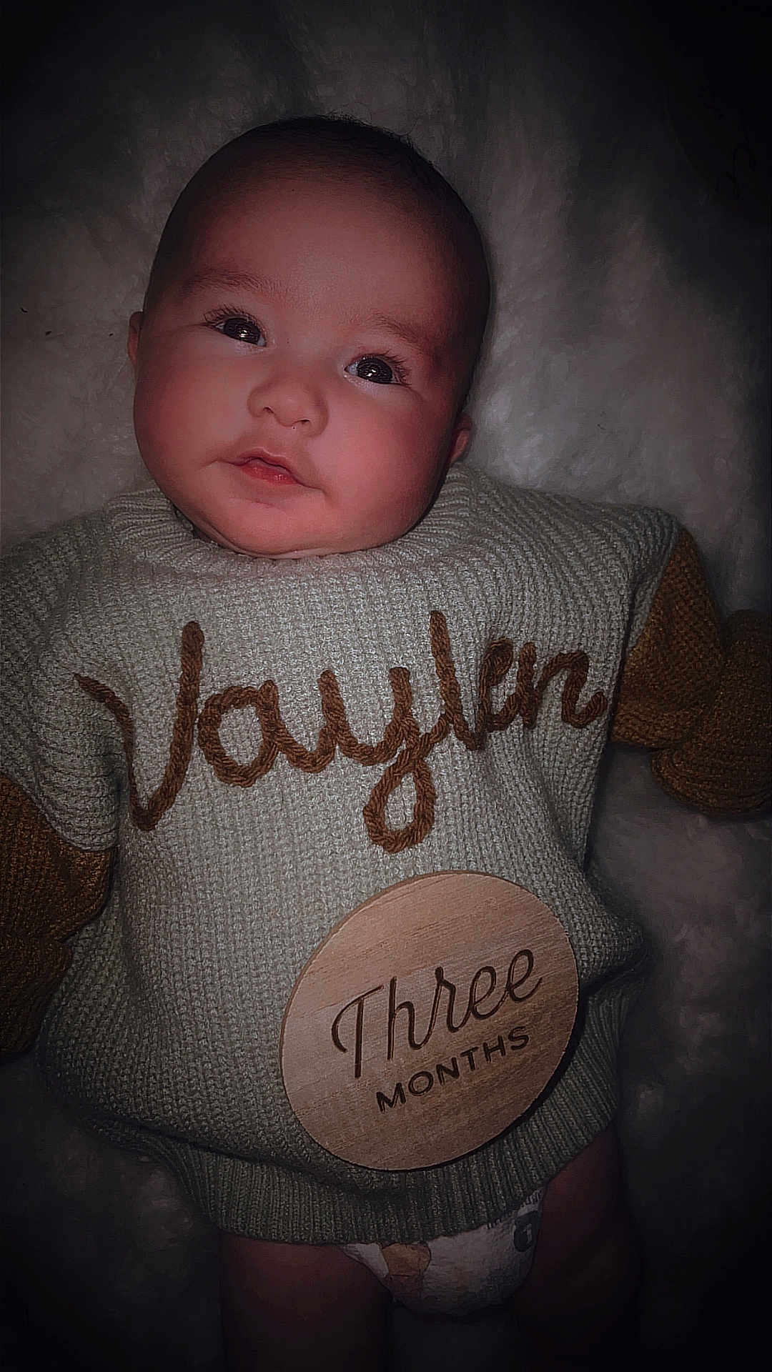 Vaylen-Stone is registered to the contest to win money with this photo: baby, calm, child, cozy, cute, diaper, face, indoors, infant, knitted_clothing, lying_down, name_embroidery, newborn, person, portrait, sleepy, soft_blanket, sweater, three_months, young_child
