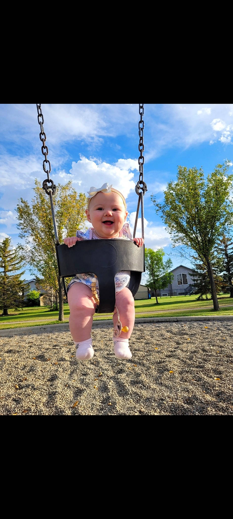 Aubrey is registered to the contest to win money with this photo: baby_toddler_clothing, cloud, flash_photography, fun, gesture, grass, happy, joy, leisure, people_in_nature, person, plant, playground, public_space, recreation, sky, sleeve, smile, standing, swing