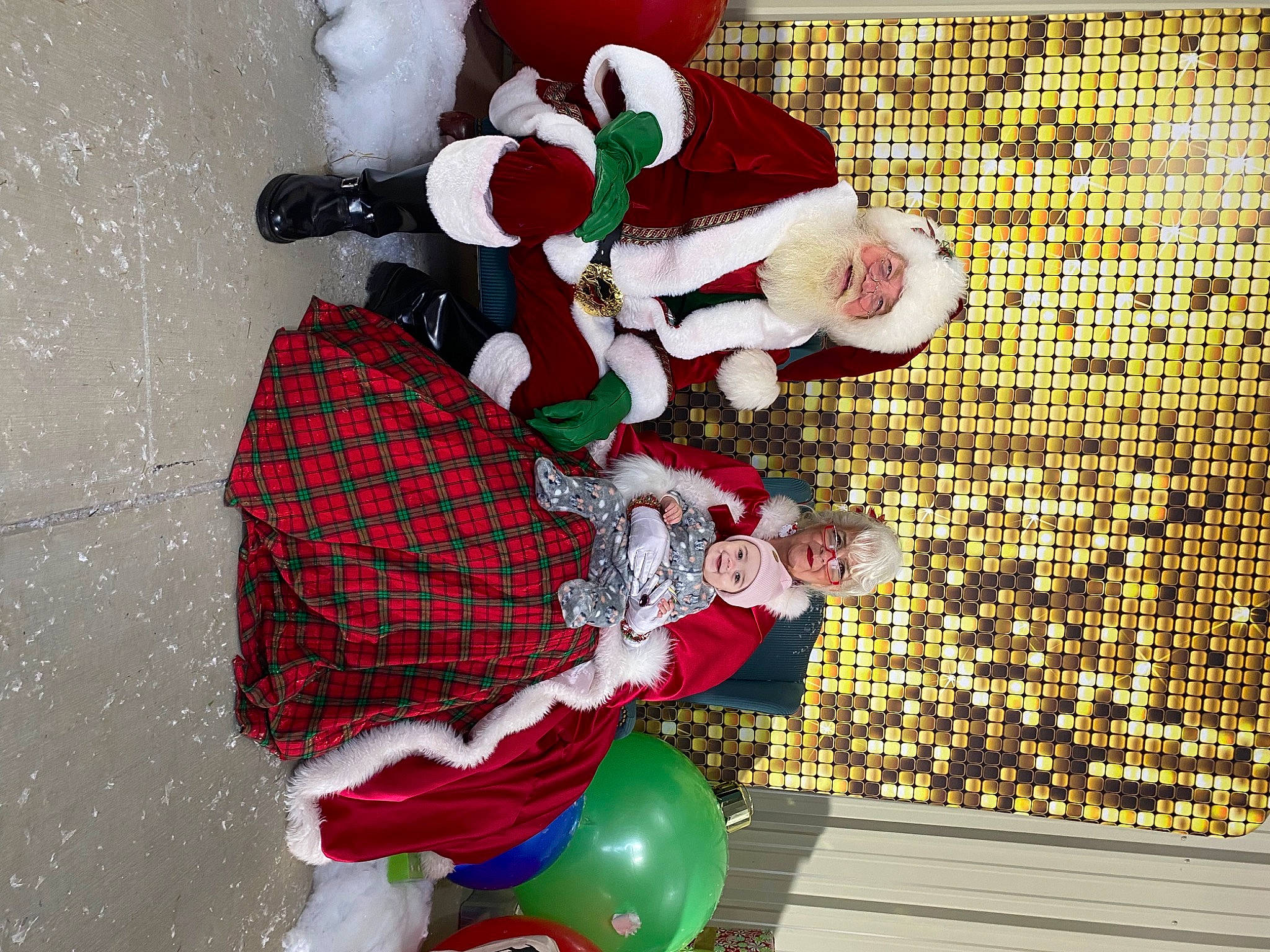 Violette is registered to the contest to win money with this photo: balloon, carmine, christmas, christmas_decoration, christmas_eve, christmas_ornament, event, fictional_character, flooring, fun, headwear, holiday, joy, lap, pattern, person, red, room, santa_claus, tartan