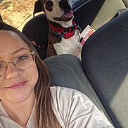 Cookie is registered to the contest to win money with this photo: animal, backseat, car, casual_clothing, collar, daylight, dog, friendly, glasses, happy, inside, leash, long_hair, pet, portrait, seat, selfie, smile, sunlight, woman