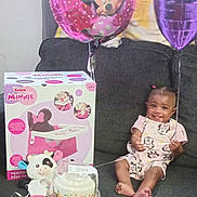 Eri'Yan is registered to the contest to win money with this photo: balloon, birthday_cake, celebration, child, clothing, couch, face, feet, gift_box, hair, happy, indoors, minnie_mouse, party, person, pink, purple, smiling, toddler, toy