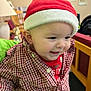 baby, checkered_shirt, child, cozy, cute, decor, face, furniture, happy, holiday, home, indoor, infant, lamp, person, portrait, red_shirt, santa_hat, smiling, wooden_chair