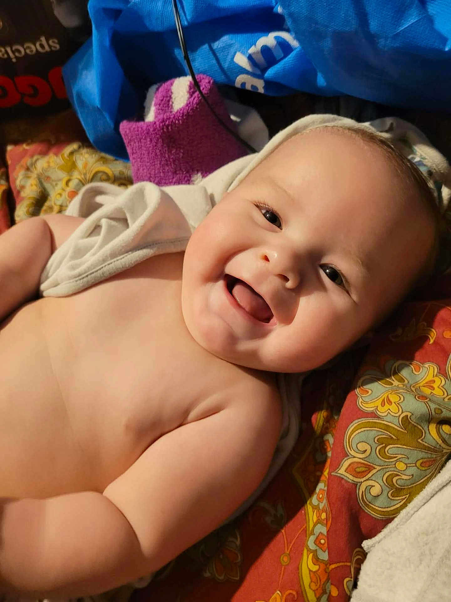 Seviin is registered to the contest to win money with this photo: baby, smiling, child, infant, blanket, towel, face, cheeks, happy, cute, skin, lying_down, closeup, indoors, portrait, expression, soft, young, warm, comfort