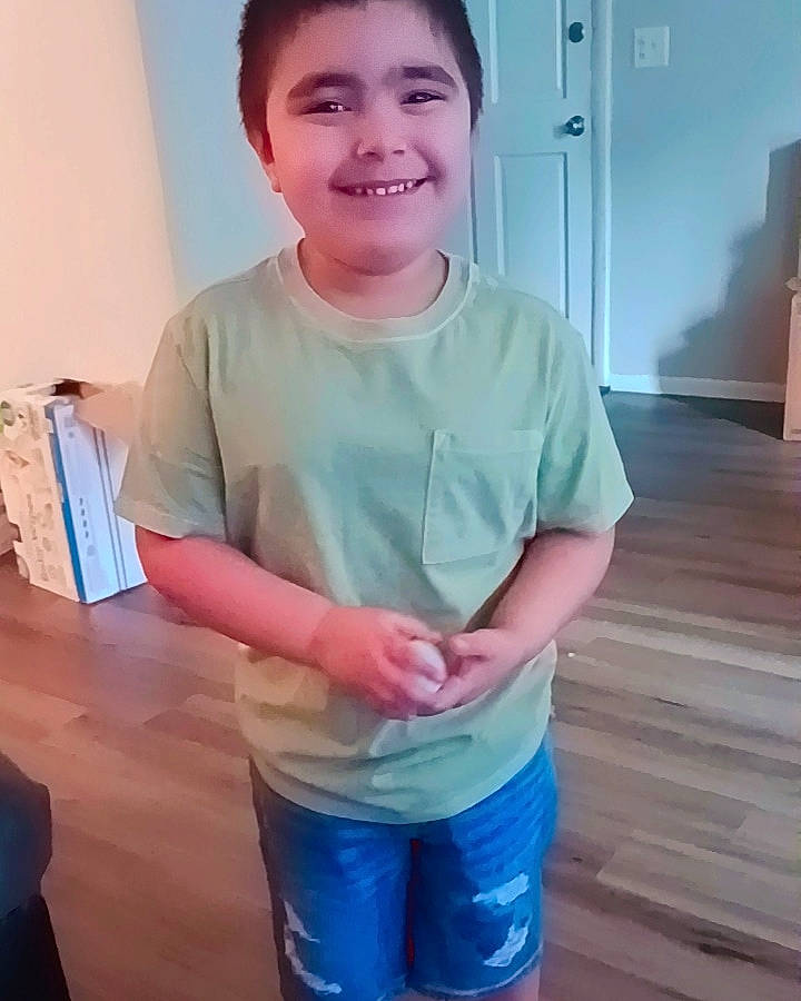 Gustavo is registered to the contest to win money with this photo: chest, child, elbow, electric_blue, fun, gesture, happy, human_leg, joy, knee, person, shorts, skin, sleeve, smile, sportswear, standing, t_shirt, thigh, thumb