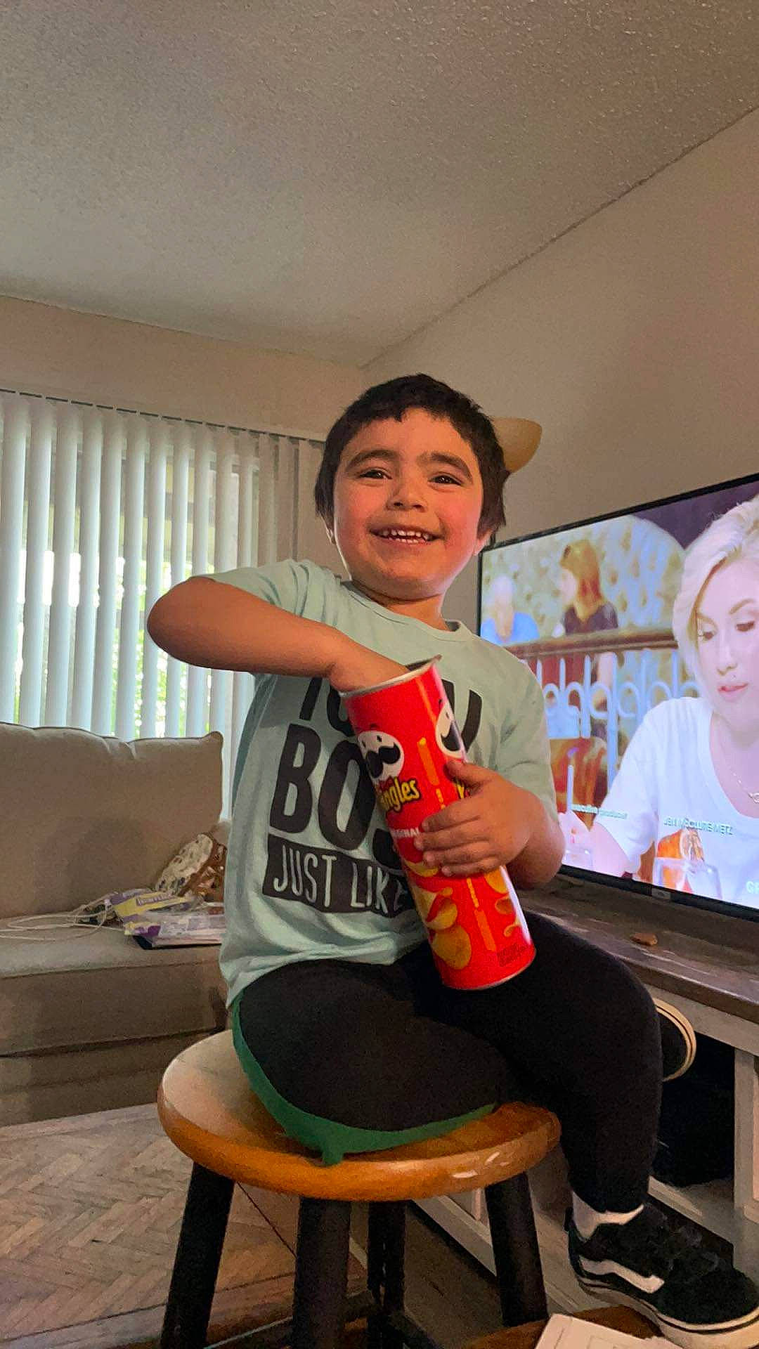 Gustavo is registered to the contest to win money with this photo: arm, child, couch, curtain, drink, event, fun, happy, joy, leisure, party, person, play, plucked_string_instruments, recreation, room, shorts, sitting, smile, string_instrument