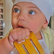 Matheo joined the competition — help win amazing prizes! baby, child, chef_hat, wooden_spatula, apron, blue_eyes, curious, indoor, kitchen, cooking, hand, face, portrait, cute, infant, person, clothing, closeup, expression, young